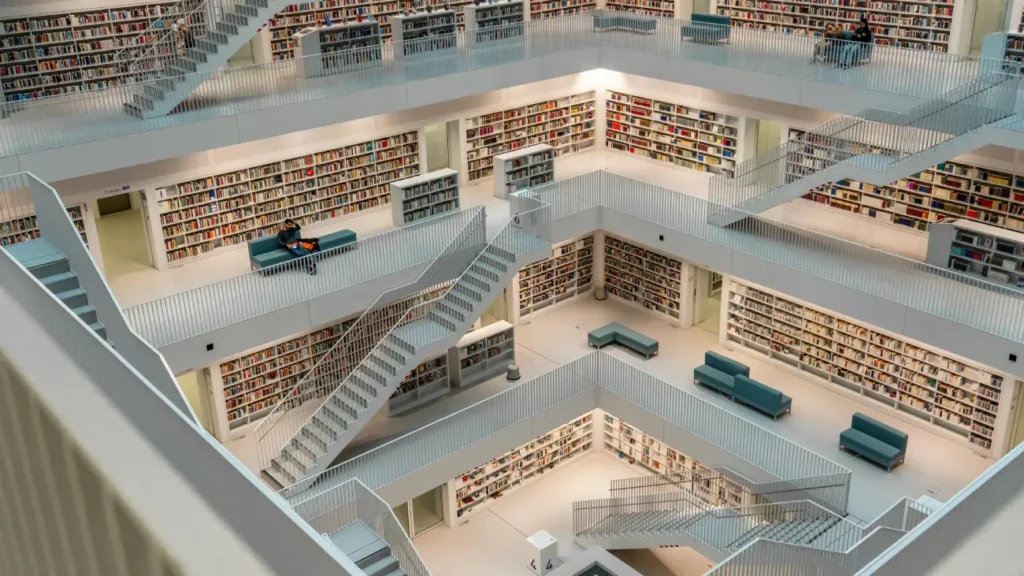 Modern, multi-level library architecture with symmetrical bookshelves and stairs.